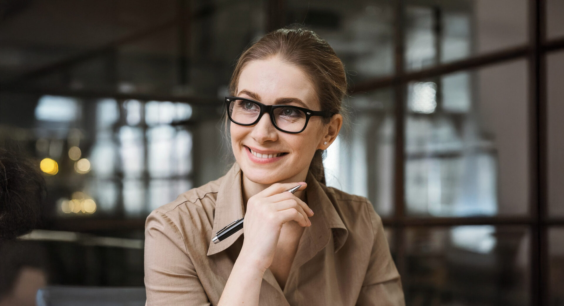 Consultante professionnelle Enseignant Femme souriante travaillant sur son ordinateur portable dans un bureau moderne
